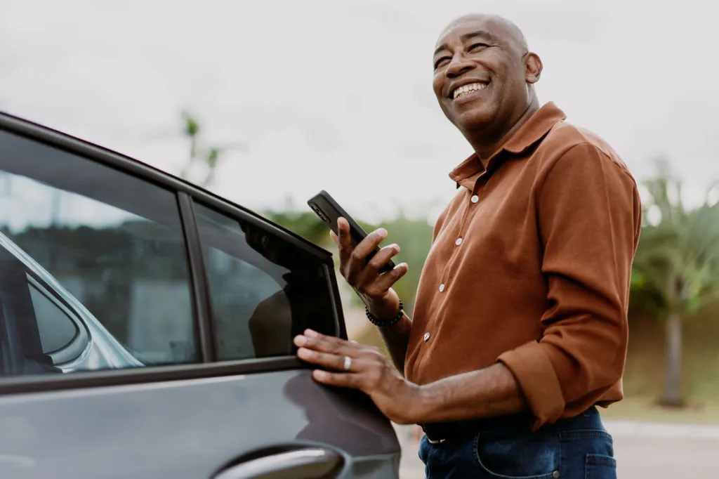 Man in brown shirt holding phone